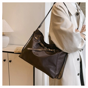 Detail of coffee tote bag with metallic buckles and high-density nylon texture