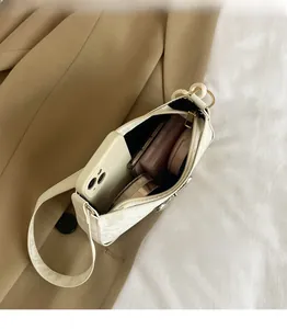 White shoulder bag interior showing capacity for smartphone and makeup items
