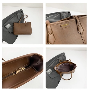 Detailed close-up of brown leather tote bag showing gold zipper and internal structure