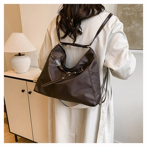Detail of adjustable leather strap and golden metal buckle on dark brown tote bag