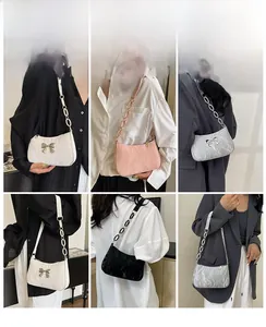Detail view of stylish underarm bags with bow accents in white, pink, silver, and black