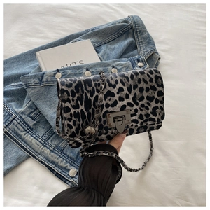 Close-up of leopard print shoulder bag with metallic turn-lock and chain strap detail