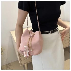 Pink bucket bag detail with golden chain strap, elegant fringe and pearl pendant decoration