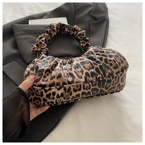 Close-up detail of leopard print patterns and pleated handle texture on the cloud bag