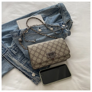 Flat lay of vintage clover print crossbody bag with silver buckle and metal chain strap