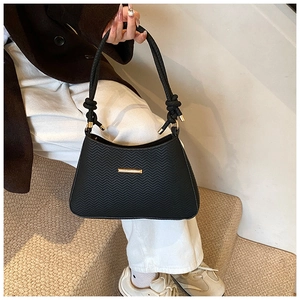 Close-up of black crossbody bag with chevron texture and elegant gold metallic hardware