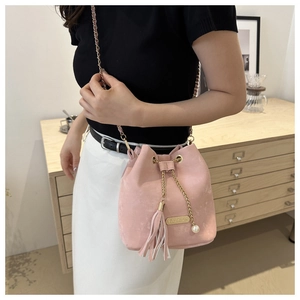 Detail of pink bucket bag with chain strap, fringe tassel and white pearl decoration