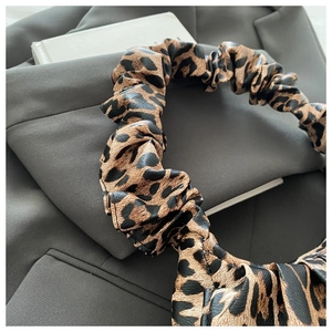 Close-up of leopard print pleated hair scrunchie with high-stretch fabric and texture