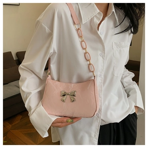 Detail of pink shoulder bag showing marble texture and silver metallic bow decoration