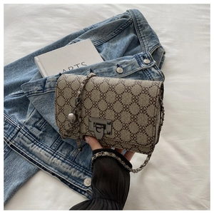 Detail of the vintage small square crossbody bag featuring metal lock and clover pattern