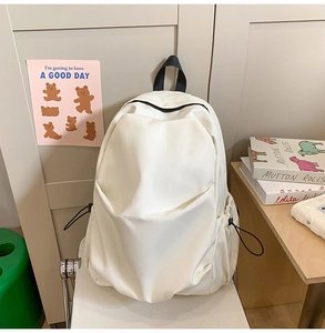 Detail of white minimalist backpack featuring adjustable drawstring side pockets for storage