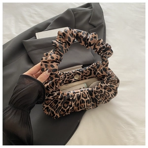 Detail of leopard print ruched cloud bag showing metallic magnetic buckle closure