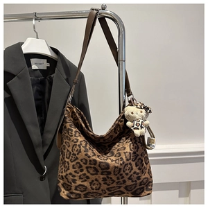 Macro detail of high-capacity leopard print hobo bag with brown leather strap