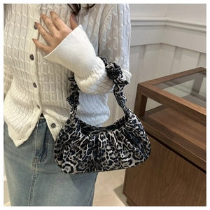 Close-up of leopard print crescent bag with pleated handle and textured fabric details