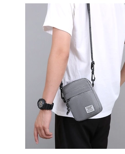 Vista dettagliata della mini borsa a tracolla in nylon grigio con cinturino regolabile