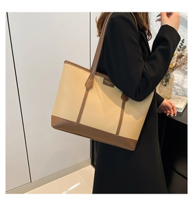 Side view of woman wearing a minimalist beige and brown tote bag for office commuting