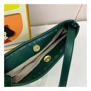 Detailed close-up of dark green PU leather texture and golden magnetic snap closure