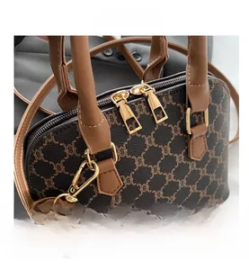 Close-up of vintage brown monogram canvas shell bag with dual gold zipper detail