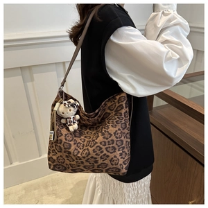 Detail of vintage leopard print hobo bag with matching plush kitty charm on long strap