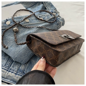 Detail view of retro brown chain bag with geometric floral print and silver buckle