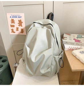 Detail view of water-resistant light grey backpack with adjustable side drawstring pockets