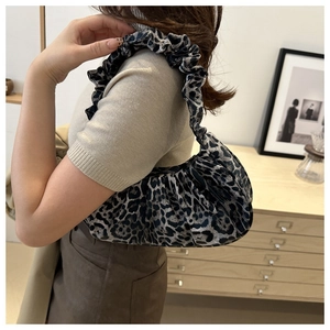 Detail of leopard print pleated crescent bag with ruffled handle in vintage setting