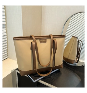 Detailed close-up of a minimalist beige and brown tote bag with fashion lettering