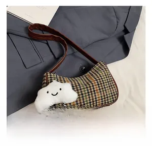 Close-up of retro plaid pattern fabric and brown leather strap with cloud charm