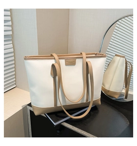 Detail of minimalist tote bag with contrast trim and leather patch in lifestyle setting