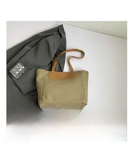 Detailed close-up of durable canvas fabric and leather handles on large tote bag