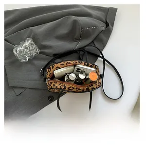 Interior view of leopard print crossbody bag showing space for phone and makeup