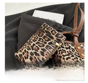Close-up of leopard print charm with golden zipper on black blazer background