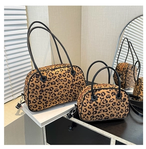 Detail view of two leopard print satchels in various sizes with leather handles