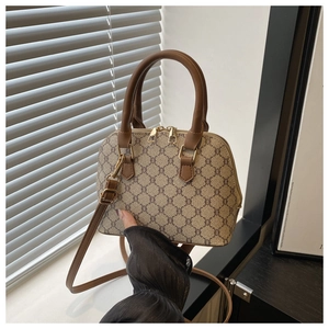 Close-up of retro monogram pattern on shell bag with premium gold metal dual zippers
