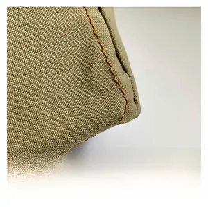 Macro shot of high-quality olive canvas fabric with precision orange stitching details