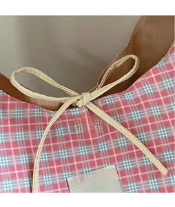 Close-up of pink checkered canvas bag with bow tie detail and woven texture