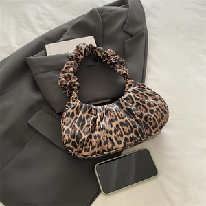 Stylish leopard print pleated crescent bag with PU leather on a grey blazer background