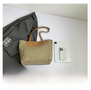 Flat lay of khaki canvas tote bag showing interior space with tablet and phone comparison