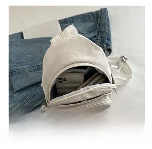 White pleated cross-body bag interior showing space for smartphone and wallet