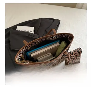 Detail view of large leopard print tote bag interior showing ample storage for tablets