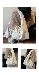 Detail of yellow and blue checkered canvas tote bag with tomato label and drawstring bow