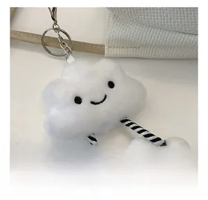Close-up of a white plush cloud charm with a smiley face on a woven tote bag