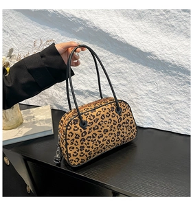 Detail view of leopard print handbag showing metal zipper hardware and slim black handles