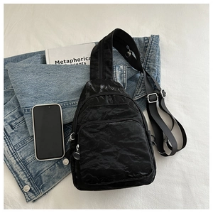Close-up of black textured waterproof chest bag with dual zippers and adjustable strap