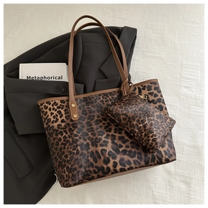 Flat lay of leopard print tote bag and matching pouch on a grey blazer with book detail