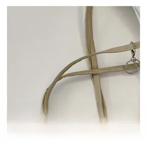 Detail view of khaki PU leather shoulder strap with silver metal buckle and neat stitching