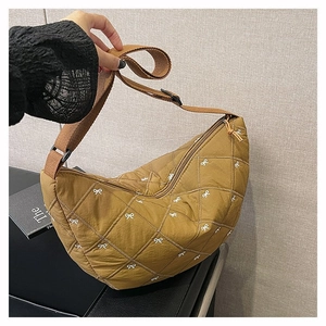 Detailansicht der braunen Stepptasche mit weißen Bogenstickereien und verstellbarem Gurt