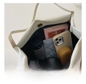 Detail view of white waffle texture tote bag interior with magnetic snap and large capacity