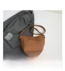 Close-up detail of brown litchi textured bucket bag with a stylish front patch pocket