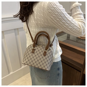 Detailed side view of a mini Boston shell bag featuring vintage monogram pattern and leather trim